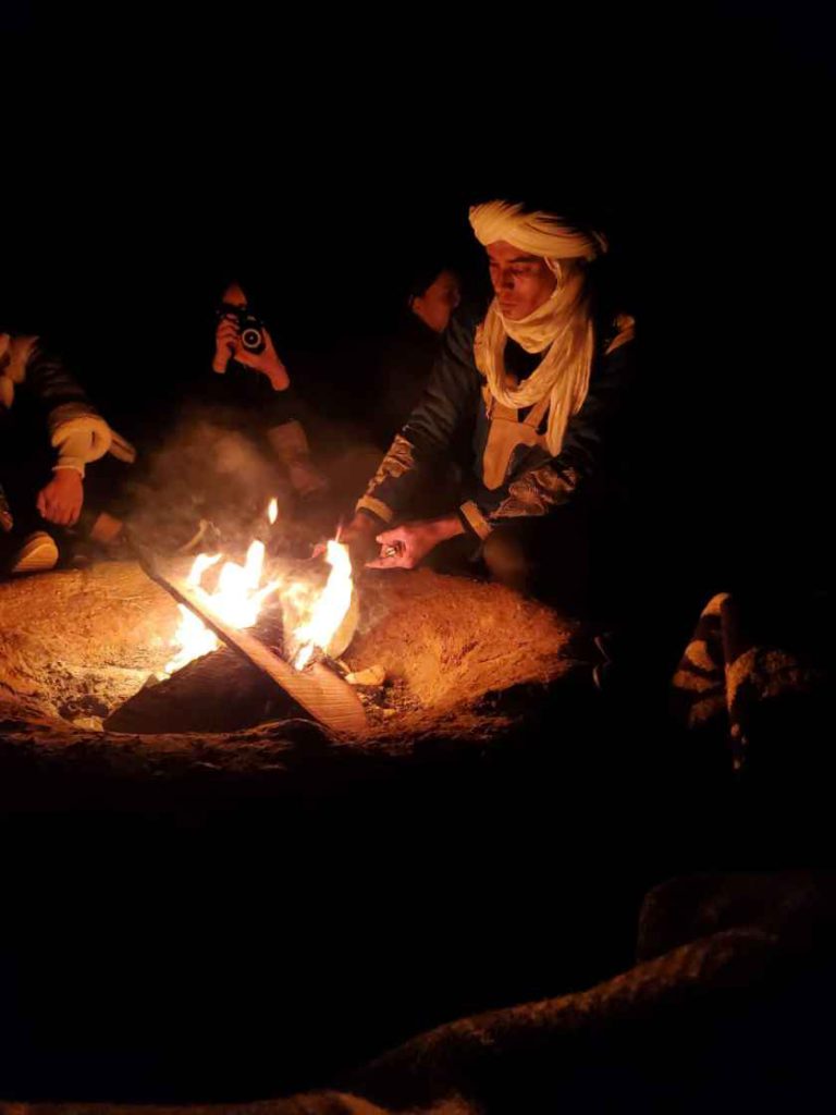 Pessoas à volta da fogueira à noite no Deserto de Zagora em Marrocos