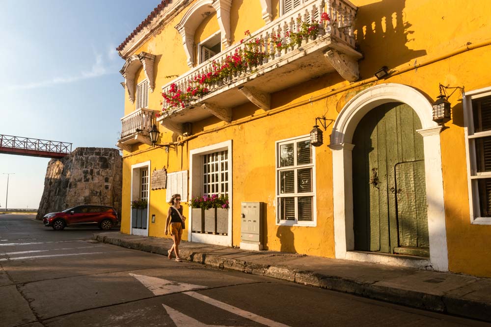 Ana a passar em frente a fachada amarela em Cartagena das Índias na Colômbia.