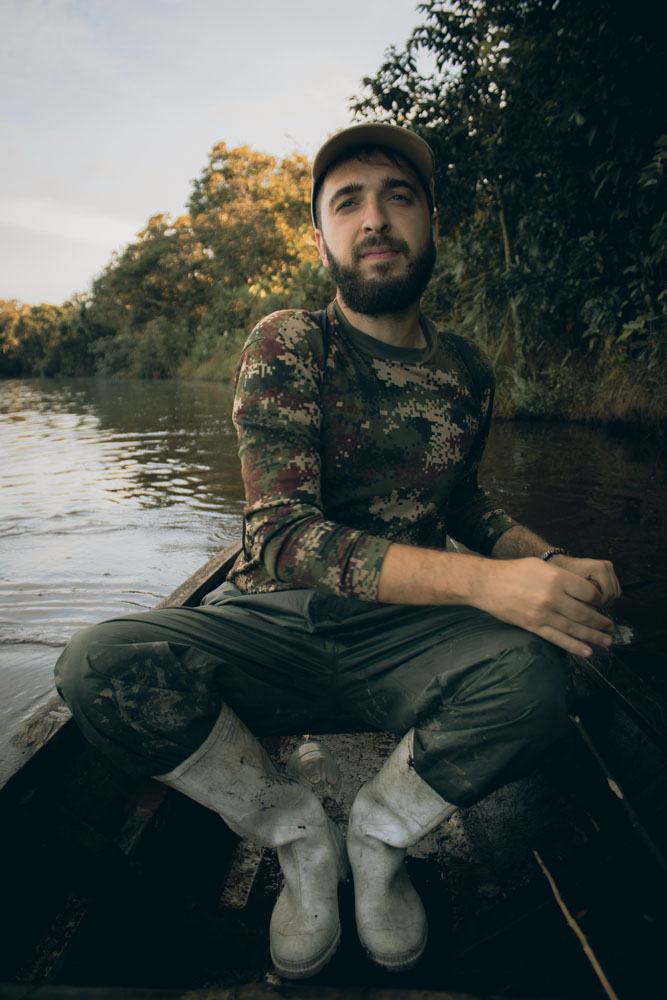 João em cima de barco de madeira num lago da Amazónia colombiana