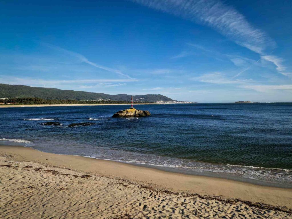 Foz do Rio Minho e ilha no meio no mar com a Mata do Camarido ao fundo