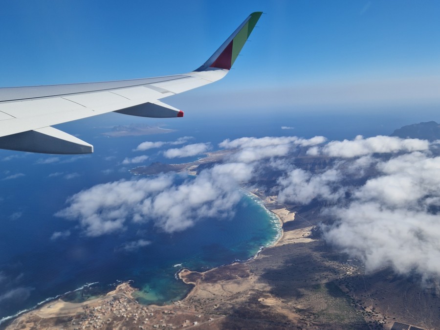 Vista aérea de São Vicente. em Cabo Verde, com algumas nuvens e uma asa de avião