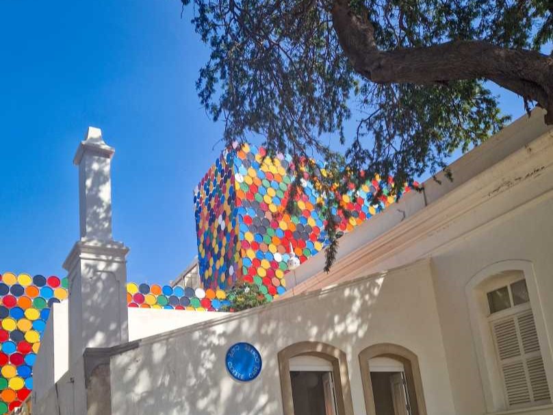 Edifício branco com colorida da fachada e uma árvore, CNAD