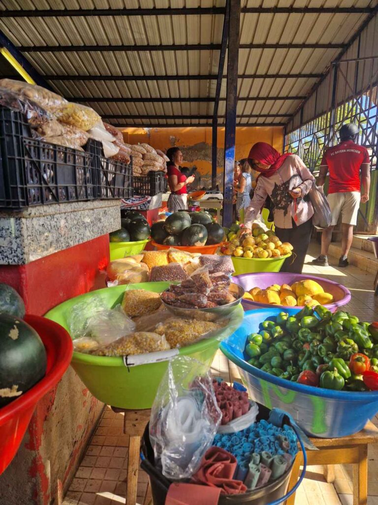 Vários legumes e grãos em bacias coloridas e sacos plásticos no mercado de Mindelo, Cabo Verde