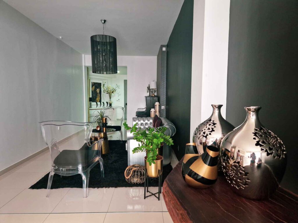 Entrada do Boutique Hotel Prassa 3, alojamento em Mindelo, com peças decorativas em tons de cinza, um sofá e cadeiras
