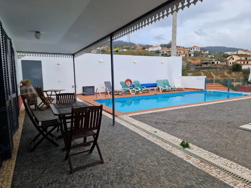 Terraço da casa com piscina, mesa e cadeiras