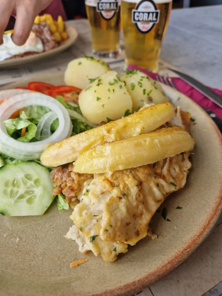 Prato de peixe-espada com banana, salada e batatas