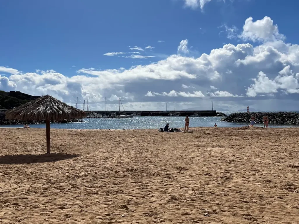 Praia do Machico com um chapéu de madeira e pessoas apanhar sol