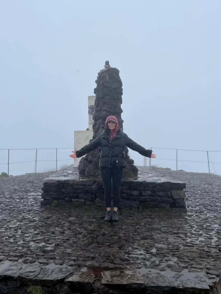 Pessoa no topo do Pico Ruivo com muita chuva