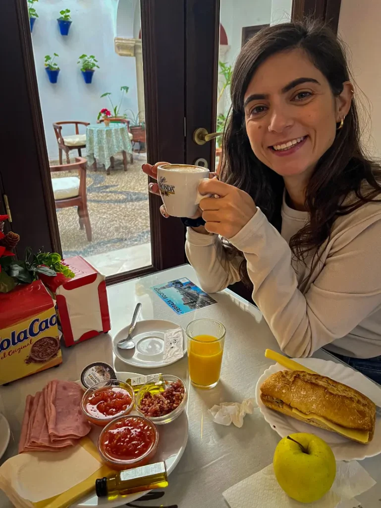 Ana a beber café em mesa com comida