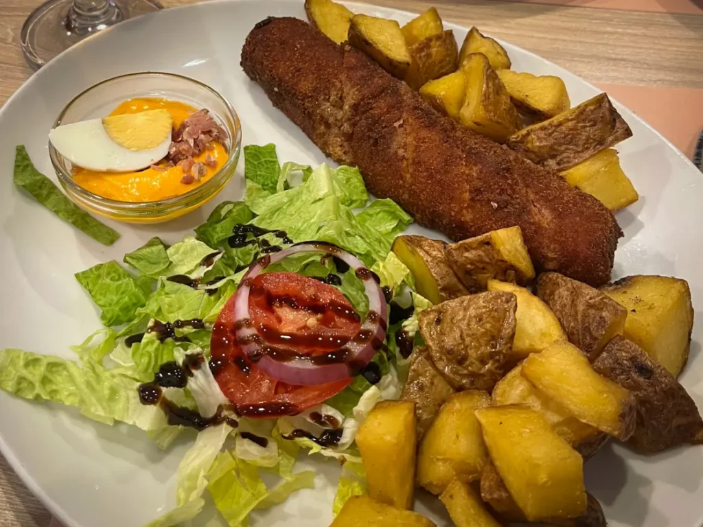 Prato de flamenquín acompanhado de salada e batatas