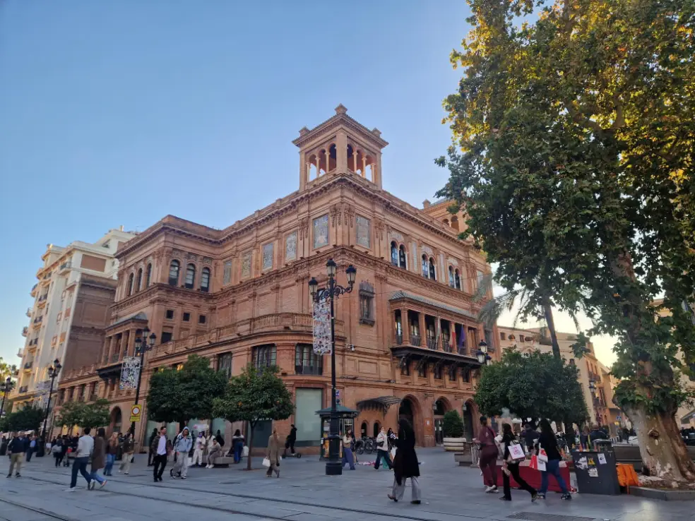 Transeuntes numa rua larga de Sevilha