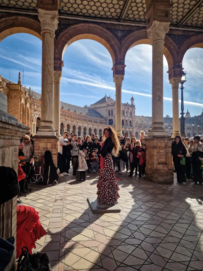 Sevilhana a dançar flamenco na Praça de Espanha em Sevilha com pessoas a assistir